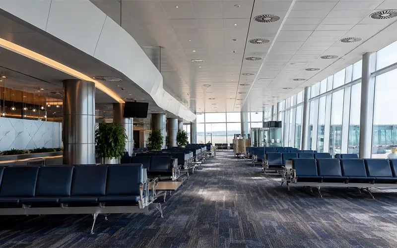 Wartebereich am Flughafen mit HLK-Deckenauslässen zur Unterstützung von Luftfiltration und saubererer Raumluft.