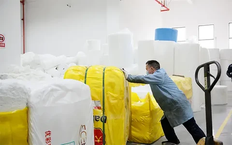 Mitarbeiter beim Transport verpackter Filtermedien im Rohmateriallager von Clean-Link