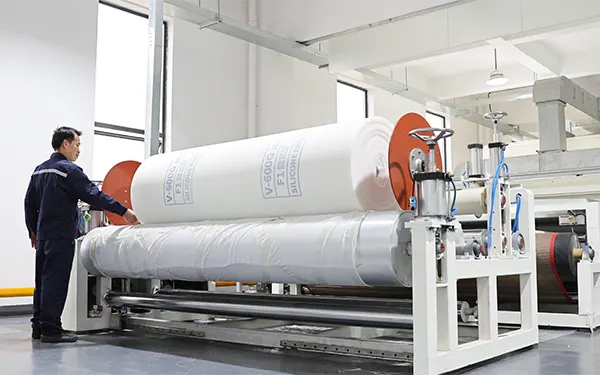 Mitarbeiter an einer Produktionsanlage zur Verarbeitung von Vorfiltermedien bei Clean-Link