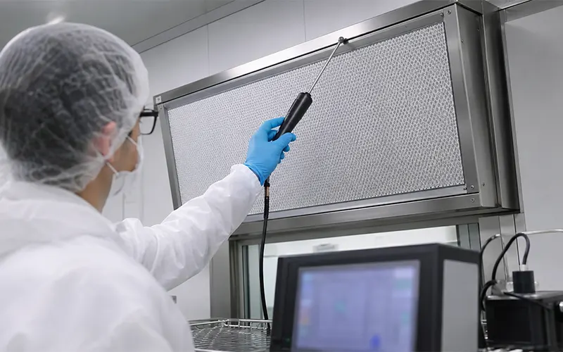 Scanbasierte Leckageprüfung eines HEPA-Filters durch einen Techniker.