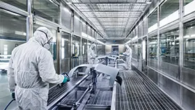 Industrielle Lackierkabine mit Mitarbeiter in Schutzkleidung bei Beschichtungsarbeiten