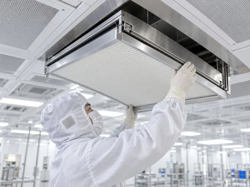 Techniker bei der Montage eines Deckenfiltermoduls in einem Reinraum.